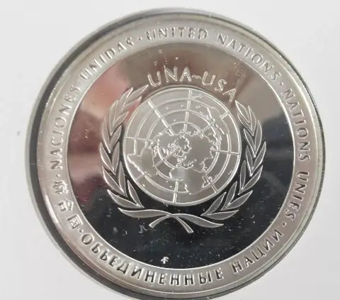 The backside of the medal is of the globe and wreath around the world with the lettering UNA-USA