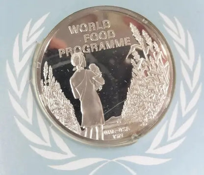This is a 1971 UNA-USA Sterling Commemorative Medal of World Food Programme. The image on the medal is of a woman holding a child. Standing next to wheat.